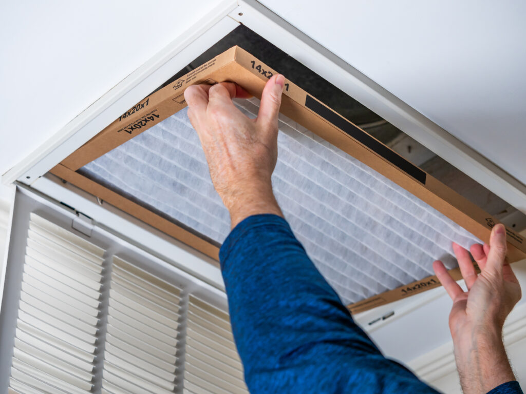 HVAC technician replacing a home air filter in Cerritos