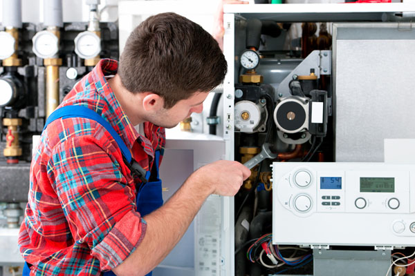 Heating technician repairing boiler controls in Cerritos