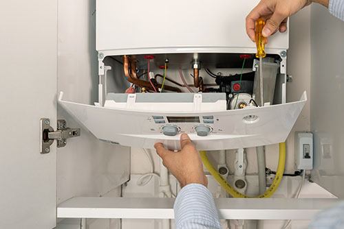 Heating technician repairing a residential boiler in Cerritos