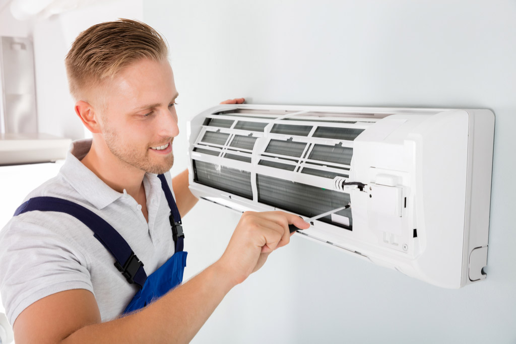 HVAC technician maintaining a ductless air conditioner in Cerritos