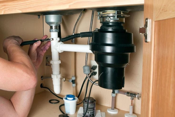 Plumber repairing a garbage disposal in Cerritos