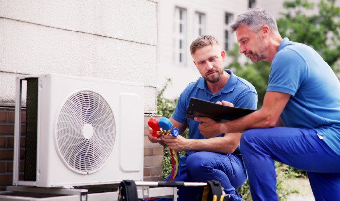 HVAC technicians installing an outdoor air conditioning unit in Cerritos