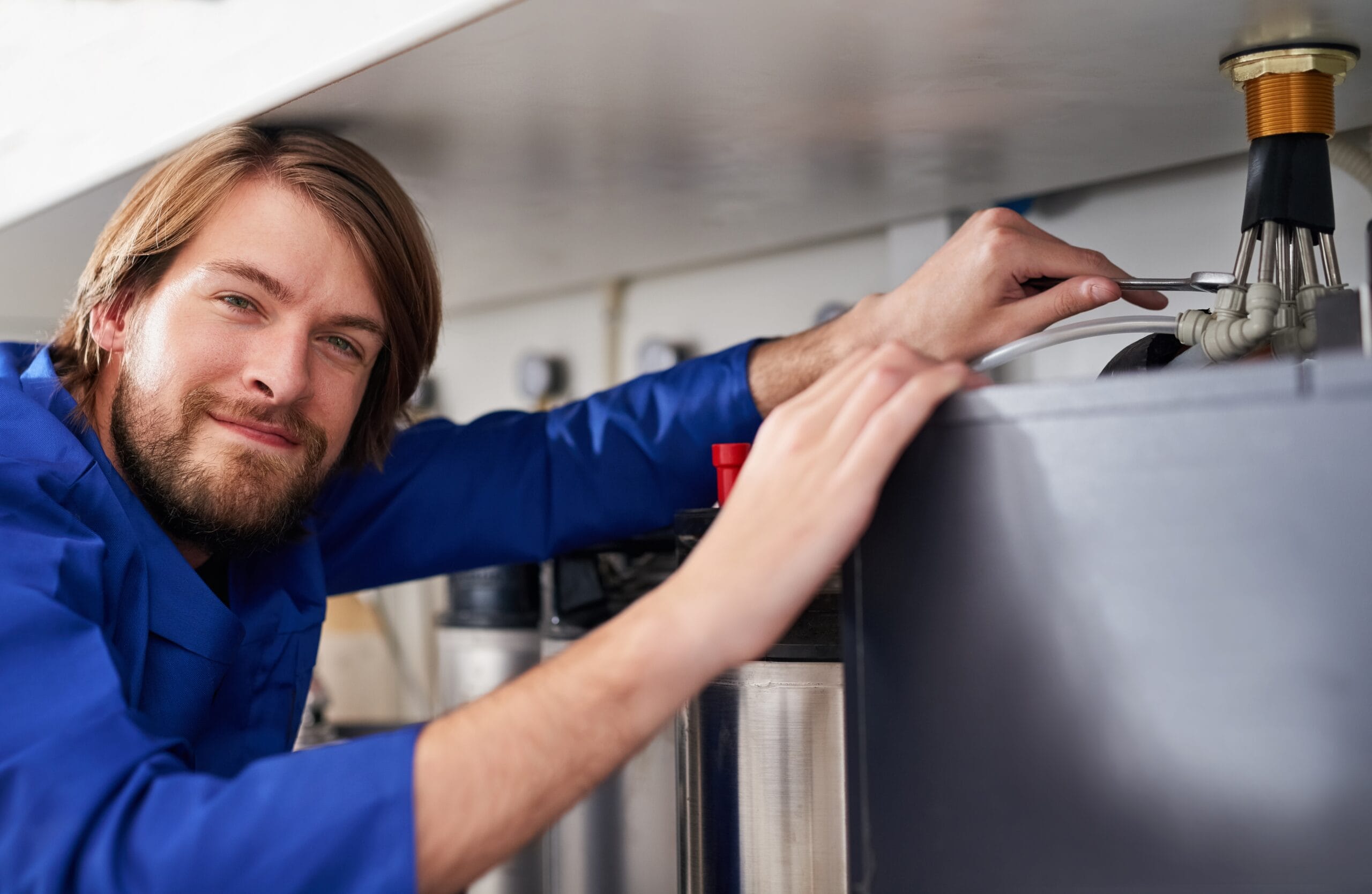 Technician servicing a residential water heater tank in Cerritos